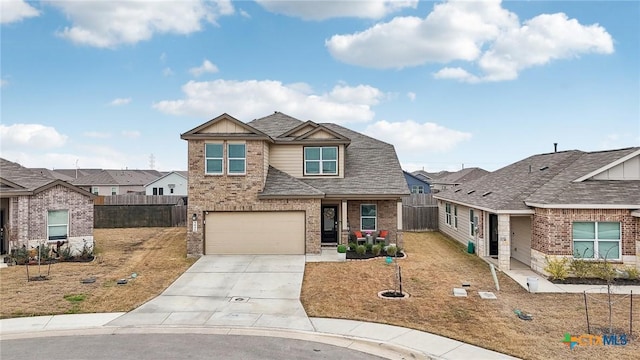 view of front of home with driveway, an attached garage, fence, and brick siding