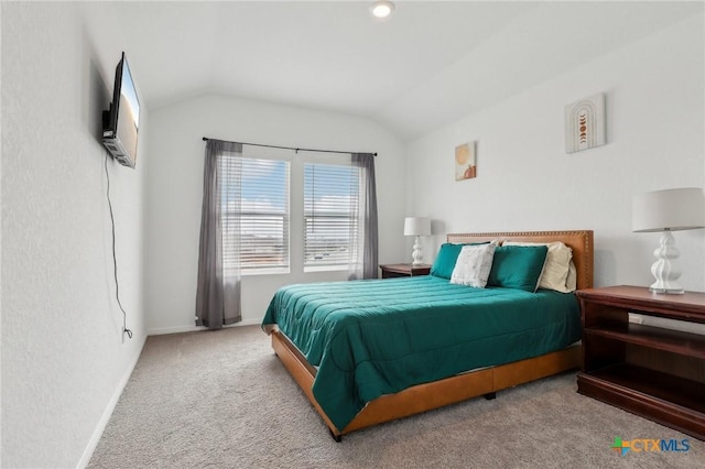 carpeted bedroom featuring baseboards and vaulted ceiling