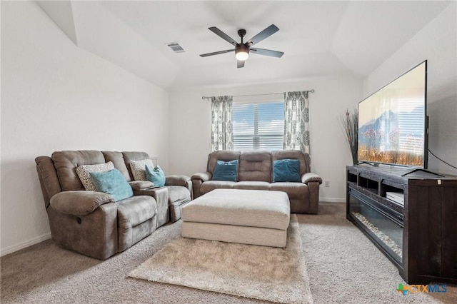 carpeted living room with a ceiling fan, visible vents, vaulted ceiling, and baseboards