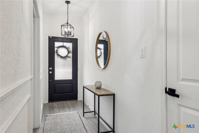 entryway featuring light wood finished floors and a notable chandelier