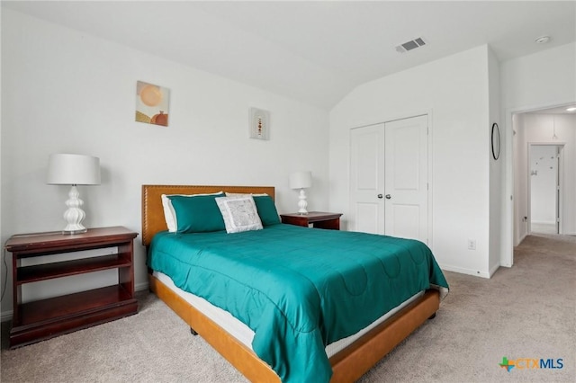 carpeted bedroom featuring lofted ceiling, a closet, visible vents, and baseboards