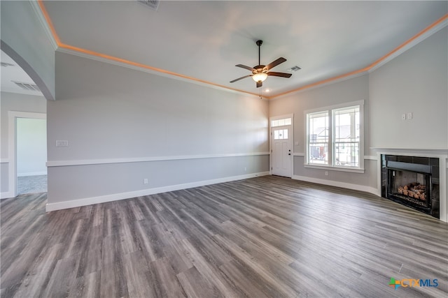 unfurnished living room with ceiling fan, a tiled fireplace, hardwood / wood-style floors, and ornamental molding