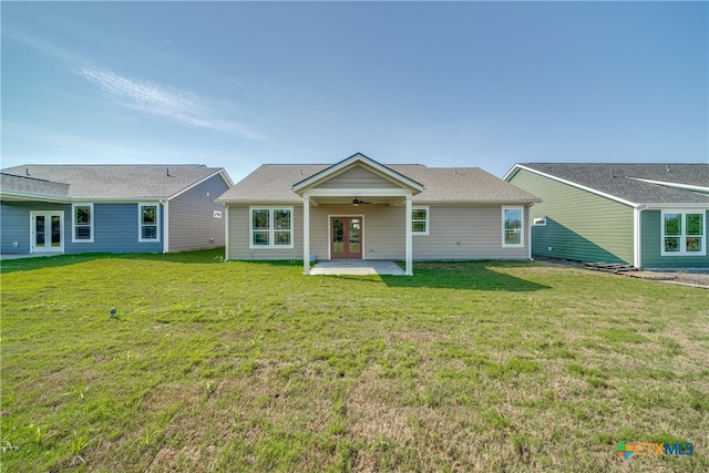 rear view of property featuring a patio, a lawn, and ceiling fan