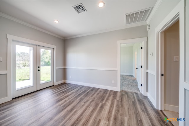 spare room featuring french doors, crown molding, and light hardwood / wood-style flooring