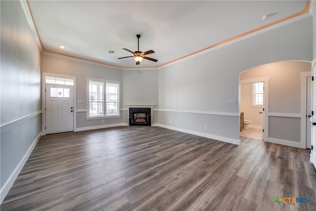 unfurnished living room with ornamental molding, ceiling fan, and dark hardwood / wood-style floors