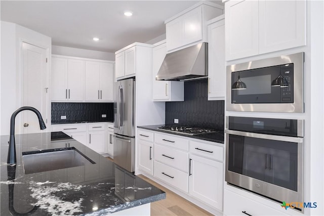 1965 Alasio Dr, Leander, TX 78641 - kitchen with appliances with stainless steel finishes, range hood, a sink, decorative backsplash, and white cabinets