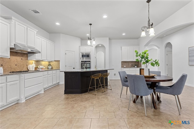 dining space with arched walkways, recessed lighting, visible vents, and baseboards