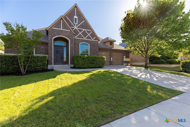 view of front of home with a garage, a front yard, concrete driveway, and brick siding
