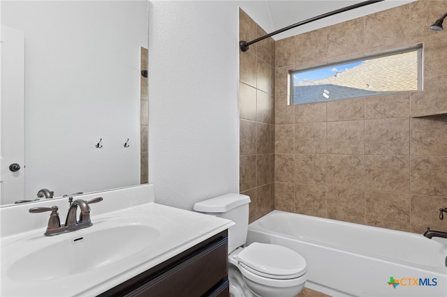 bathroom featuring toilet, shower / bathing tub combination, vanity, and a textured wall