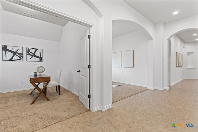 hall featuring arched walkways, light colored carpet, visible vents, recessed lighting, and baseboards