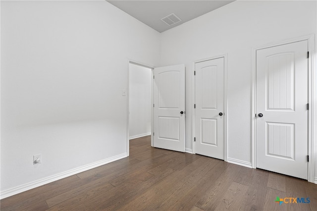 unfurnished bedroom with visible vents, baseboards, and wood finished floors