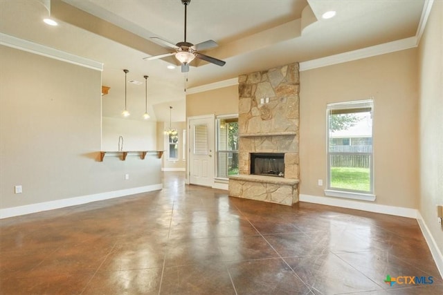 703 Cosper Creek Dr, Killeen, TX 76542 - unfurnished living room featuring crown molding, ceiling fan, a stone fireplace, and a raised ceiling