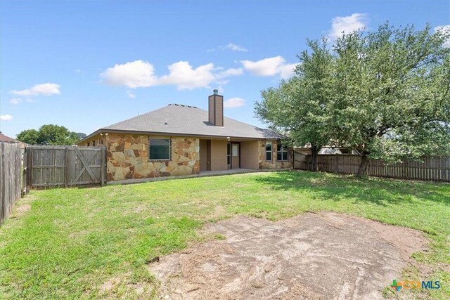 703 Cosper Creek Dr, Killeen, TX 76542 - rear view of property featuring a chimney, a fenced backyard, and stone siding