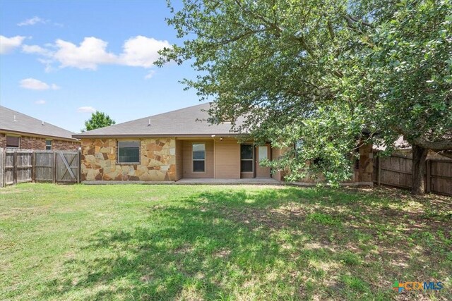 703 Cosper Creek Dr, Killeen, TX 76542 - rear view of property with a fenced backyard, stone siding, and a patio