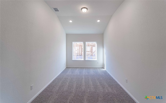 spare room featuring carpet floors and vaulted ceiling