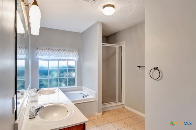 bathroom featuring vanity, tile patterned flooring, shower with separate bathtub, and a textured ceiling