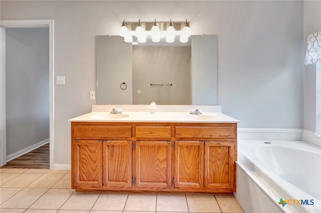 bathroom featuring tile patterned flooring, vanity, and a tub