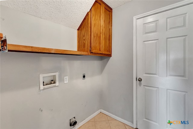 laundry area with cabinets, washer hookup, a textured ceiling, light tile patterned floors, and electric dryer hookup