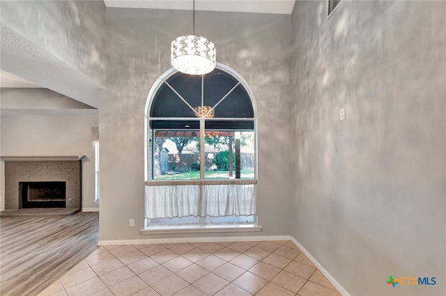 unfurnished living room with light tile patterned flooring and a towering ceiling