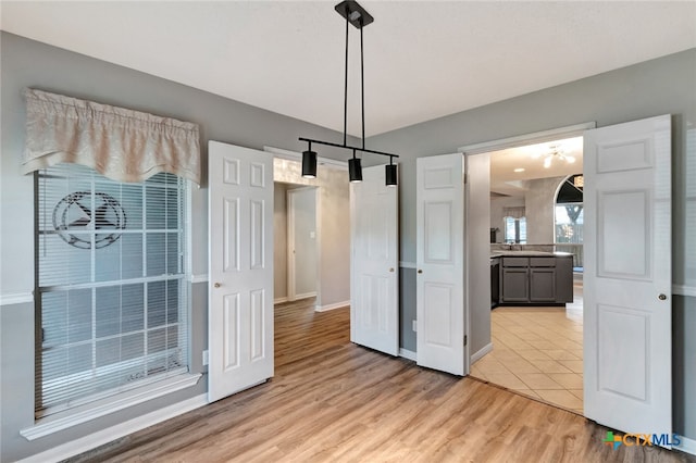 unfurnished dining area with sink and light hardwood / wood-style flooring