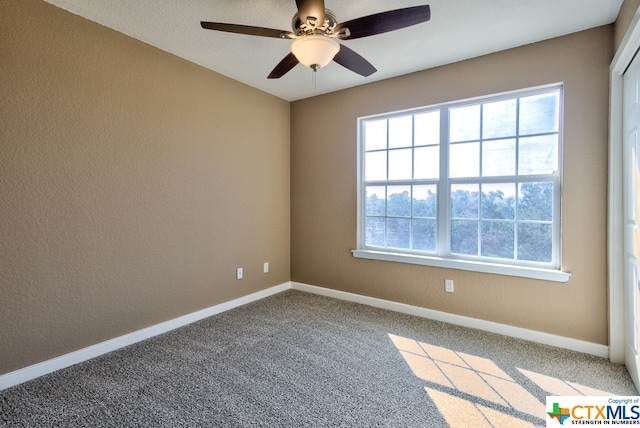 unfurnished room featuring ceiling fan and carpet