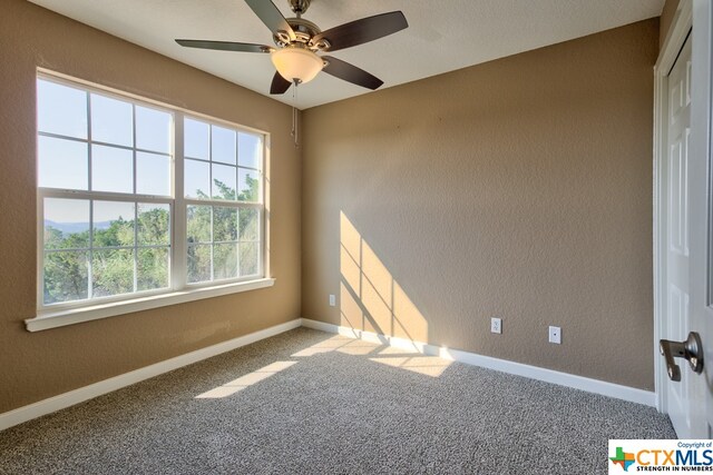 carpeted empty room featuring ceiling fan