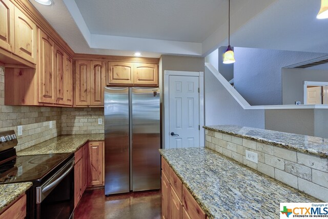 kitchen featuring tasteful backsplash, light stone countertops, appliances with stainless steel finishes, and decorative light fixtures