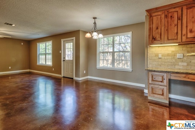 3037 Rustler, Canyon Lake, TX 78133 - kitchen with finished concrete floors, a textured ceiling, open floor plan, decorative backsplash, and a chandelier