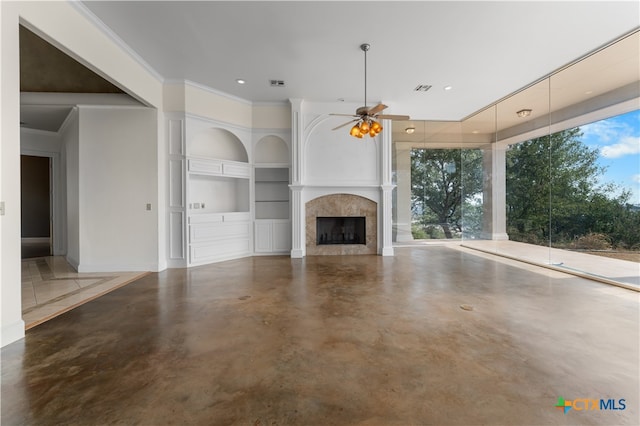 unfurnished living room featuring built in shelves, ornamental molding, ceiling fan, and concrete floors