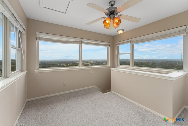 unfurnished sunroom featuring ceiling fan