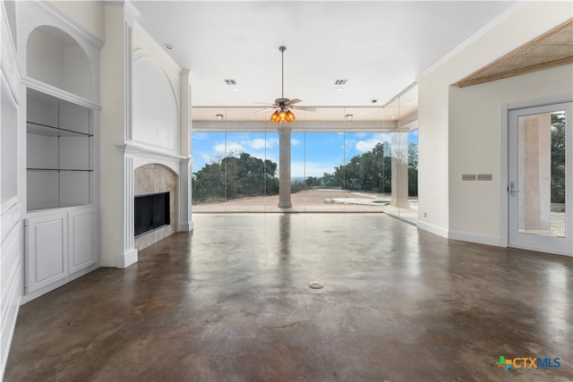 unfurnished living room featuring ceiling fan, a large fireplace, and crown molding