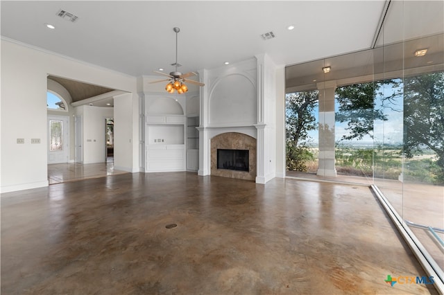 unfurnished living room featuring built in shelves, ceiling fan, and a tile fireplace