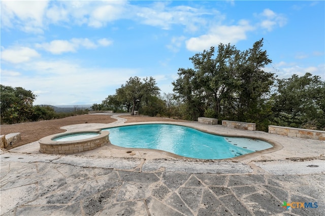 view of pool featuring a patio and an in ground hot tub