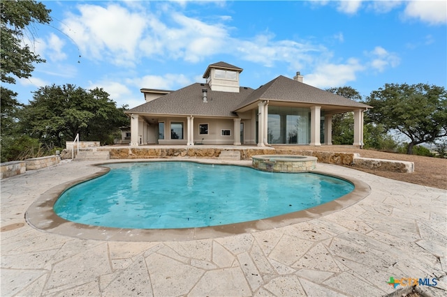 view of pool featuring a patio and an in ground hot tub