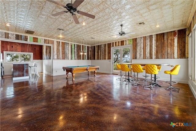 rec room with bar, a wealth of natural light, and ceiling fan