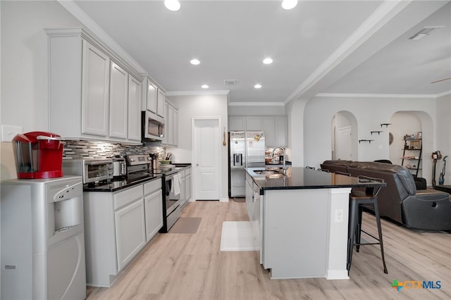 1444 Rolling Brook Dr, Temple, TX 76502 - kitchen featuring appliances with stainless steel finishes, open floor plan, ornamental molding, a sink, and dark countertops
