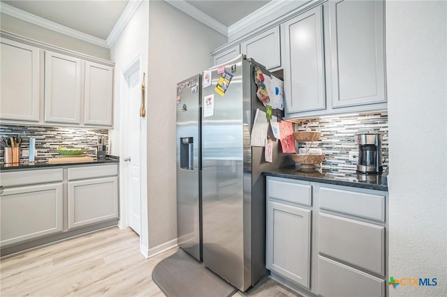 1444 Rolling Brook Dr, Temple, TX 76502 - kitchen with stainless steel fridge, tasteful backsplash, dark countertops, light wood-style floors, and ornamental molding