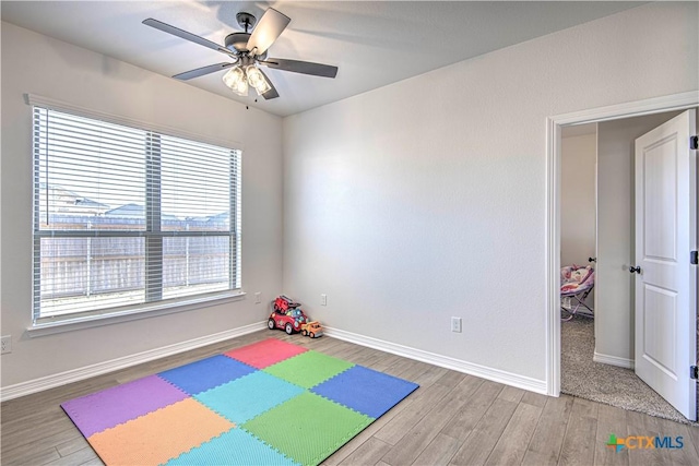 playroom with a healthy amount of sunlight, hardwood / wood-style floors, and ceiling fan