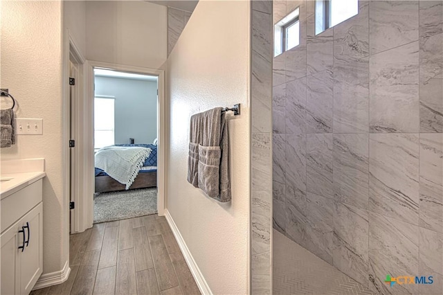 bathroom with vanity and a tile shower