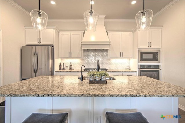 kitchen featuring hanging light fixtures, custom exhaust hood, stainless steel appliances, and white cabinets