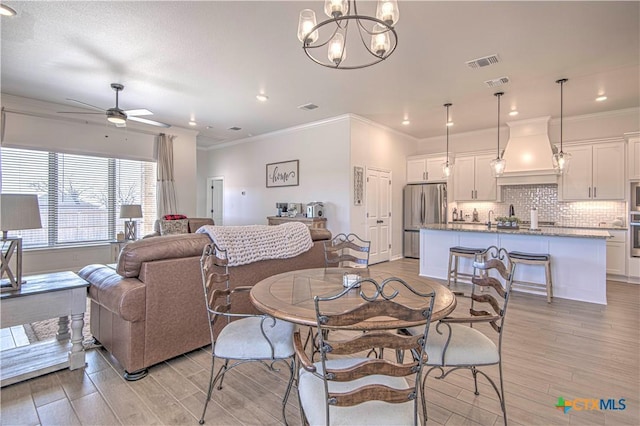 dining space featuring crown molding and ceiling fan with notable chandelier