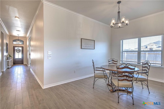 dining area with crown molding, wood-type flooring, a chandelier, and a textured ceiling