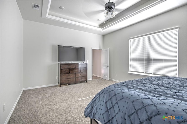 bedroom featuring a raised ceiling, carpet flooring, and ceiling fan