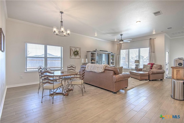 living room featuring ceiling fan with notable chandelier, ornamental molding, and light hardwood / wood-style floors