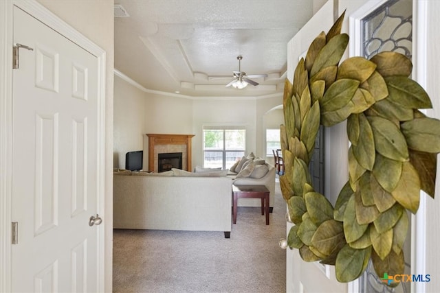 living room with ornamental molding, a textured ceiling, carpet floors, and ceiling fan