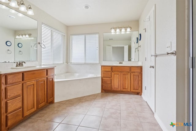 bathroom featuring tile patterned flooring, a washtub, and vanity