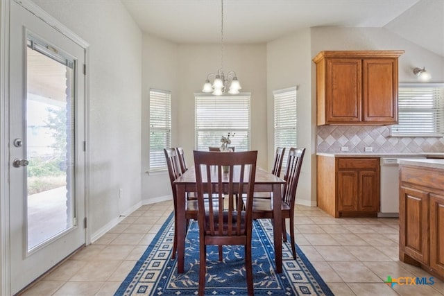 tiled dining area with vaulted ceiling, a notable chandelier, and plenty of natural light