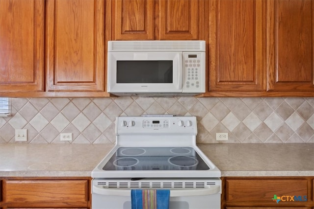 kitchen with decorative backsplash and white appliances