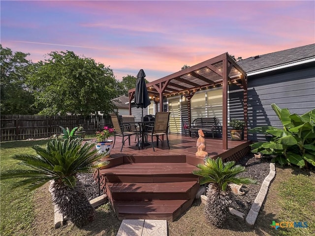 701 Clark St, Gonzales, TX 78629 - deck at dusk with outdoor dining space and a pergola