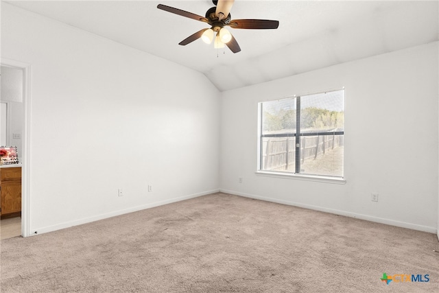 spare room with lofted ceiling, light colored carpet, and ceiling fan